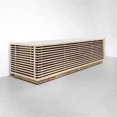 a large wooden object sitting on top of a white floor in front of a wall