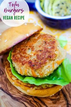 a burger with lettuce and cheese on it sitting on top of a wooden cutting board