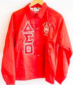 a red coach jacket with white letters on it