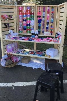 a wooden bench with lots of bracelets on it and two stools next to it