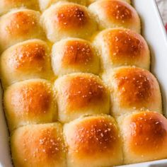 a white casserole dish filled with bread rolls