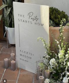 a sign that says the path starts now next to some flowers and candles in front of it