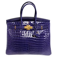 Introducing the epitome of luxury and sophistication, the Hermes Birkin 35cm Amethyst Shiny Porosus Crocodile Gold Hardware handbag. Crafted in 2020, this iconic handbag is a testament to Hermes' impeccable craftsmanship and timeless design. This stunning Birkin handbag features the rare and coveted Amethyst shade in luxurious shiny Porosus crocodile leather, exuding elegance and opulence. The deep purple hue adds a touch of sophistication to any ensemble, making it a versatile statement piece for any occasion. The gold hardware accents beautifully complement the rich color of the crocodile leather, elevating the bag's allure and adding a touch of glamour. The Birkin 35 size offers ample space for all your essentials, making it both practical and stylish. As one of the most iconic and soug Purple Birkin, Birkin Bag Price, Cartier Earrings, Statement Handbag, Birkin Handbags, Hermes Birkin 35, Nike Fashion Shoes, Denim Shoulder Bags, Favorite Handbags