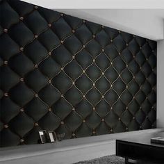 a black and white photo of a living room with a leather wall covering the walls