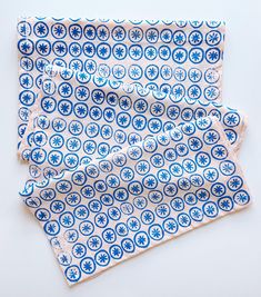 two blue and white napkins sitting on top of each other next to each other