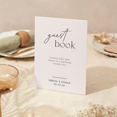 the guest book sits on top of a table with plates and napkins around it