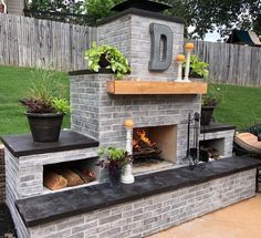 an outdoor fireplace with potted plants on top