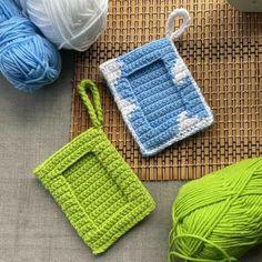 two crocheted items are sitting next to each other on a mat with yarn