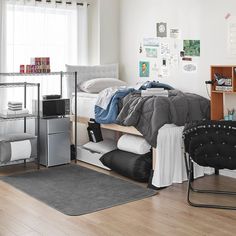 a bed room with a neatly made bed next to a desk and chair in front of a window