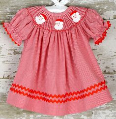 Smocked Santa Dress. Hand Smocked Christmas Dress, Perfect for Baby Girl Christmas Dress. Ideal Girls Santa Dress, Toddler Christmas Dress, and First Christmas Dress! **IN STOCK & READY TO SHIP** This is a lovely detailed Santa smocked bishop dress is on a beautiful red gingham fabric! Trimmed with red ric rac, this is a must have for your little ones Holiday wardrobe! Check out our matching brother longall! https://www.etsy.com/DovieJaneClothing/listing/246354866 Size chart located in the a Red Smocked Bodice Dress For Holiday, Red Holiday Dress With Smocked Bodice, Holiday Dresses With Smocked Back, Girls Smocked Christmas Dress, Smocked Christmas Dress, Girls Santa Dress, Baby Girl Christmas Dress, Christmas Dress Girls, Smocked Christmas Dresses