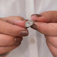 two hands holding a diamond ring in their left and right hand, while another person holds the other