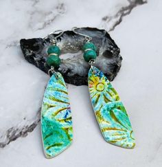 A pair of polymer clay earrings. The polymer clay has chalk designs and is sealed. It dangles from two imitation turquoise gemstone beads. Chalk Designs, Spider Earrings, Shell Choker, Earrings Handmade Dangle, Turquoise Cross, Pumpkin Earrings, Wire Wrapped Necklace, Wire Wrapped Earrings, Cross Earrings