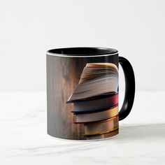 a stack of books sitting on top of a table next to a cup with liquid in it