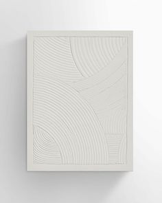 a white wall hanging on the side of a wall with an abstract design in it