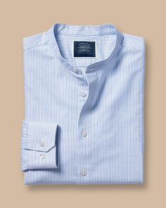 100% cotton, Available in slim fit, Collarless, Mitred button cuff with two buttons, Oxford Weave, Mid-weight, Split back yoke, Machine washable - Collarless Stretch Washed Oxford Stripe Shirt - Ocean Blue | Men's Charles Tyrwhitt Collarless Stretch Washed Oxford Stripe Casual Shirt - Ocean Blue Single Cuff Size Large Cotton Summer Cotton Shirt With Fold Down Collar, Cotton Summer Shirt With Fold Down Collar, Slim Fit Cotton Shirt With Button Cuffs, Slim Fit Cotton Top With Fold Down Collar, Cotton Slim Fit Top With Fold Down Collar, Cotton Tops With Slim Fit And Fold Down Collar, Classic Slim Fit Top With Placket, Casual Slim Fit Top With Fold Down Collar, Cotton Shirt With Fold Down Collar And Buttons