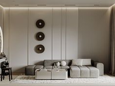 a modern living room with white walls and grey furniture in the center, along with three circular artwork pieces on the wall