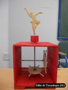 a small red box with a wooden figure on top