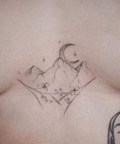 a woman's chest with a mountain and moon tattoo on her left side breast