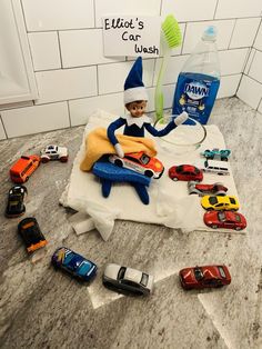 an elf is sitting on top of a counter with toy cars and toothbrushes