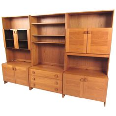 three wooden shelves with drawers and cupboards