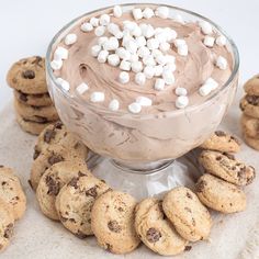 cookies and marshmallows are arranged around a bowl of chocolate pudding