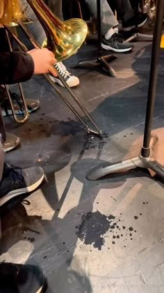 a group of people playing musical instruments in a room with black and white flooring