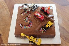 a birthday cake with construction trucks and cars on it