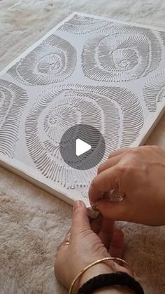 a person is using scissors to cut out an intricate design on a piece of paper