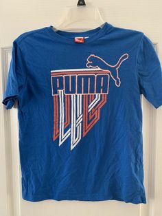 Puma ~short sleeve T-shirt ~ boys size M ~ blue With Logo. Super cool front logo design Puma cat logo on back Please excuse the wrinkles 😉 Shipped with USPS First Class. Front Logo Design, Puma Logo Sporty T-shirt For Sports, Puma Logo Cotton Graphic Tee, Puma Tshirts, Crew Neck Cotton T-shirt With Puma Logo, Cheap Puma Logo Sports T-shirt, Puma Cat, Kids Tshirt, Cat Logo