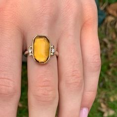 Like a little ray of sunshine on your finger. This vibrant citrine is set in 14k gold atop a handmade sterling silver band. Flanked by brilliant white diamonds. Approx stone size: 16mm x 10mm Approx ct weight: 5.95cts Mohs Hardness: 7 This one of a kind piece is handmade to in Emily's Hudson Valley studio. This piece is in stock and can be resized prior to shipping. If you have questions about sizing, shipping or need help deciding please reach out to us! Yellow Diamond Ring With Gemstones In Sterling Silver, Yellow Diamond Ring In Sterling Silver, Sterling Silver Yellow Gold Topaz Ring With Polished Finish, Yellow Gold Topaz Ring In Sterling Silver, Yellow Gold Topaz Ring With Polished Sterling Silver, Sterling Silver Yellow Gold Topaz Ring With Center Stone, Yellow Gold Topaz Ring With Sterling Silver, Yellow Sterling Silver Rings With Diamond Accents, Gold Topaz Ring With Center Stone In Sterling Silver