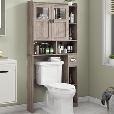 a white toilet sitting in a bathroom next to a wooden cabinet