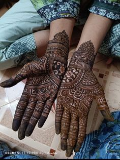 two hands with henna designs on them