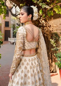 Golden White Lehenga Choli for Indian Bridal Wear a Heavily Embellished Bridal Choli Gown encrusted with Swarovski stones, Resham embroidery, and kora Dhaka along with a heavily embellished lehenga. Also, this is a handwoven silk lehenga with 16 organza panels. White Choli: A magical ethereal white outfit is precisely embellished with dazzling sequins, crystal, and pearls creating a divine embroidered composition with Mukesh. Korean silk choli is crafted in full-on hand embellishments with a mod Hand Embellished Raw Silk Lehenga For Eid, Traditional Hand Embellished Lehenga For Eid, Traditional Hand Embellished Gown For Reception, Traditional Hand-embellished Gown For Festivals, Hand Embellished Chinon Lehenga For Eid, Hand Embellished Raw Silk Choli For Festivals, Hand Embellished Raw Silk Choli With Traditional Drape, Traditional Gold Hand-embellished Choli, Traditional Hand Embellished Wedding Wear