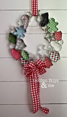 a christmas wreath hanging on the side of a white wall with red and green gingham ribbon