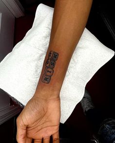 a person's hand with a tattoo on their left wrist and the word god written in black ink