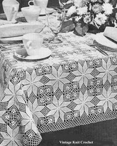 an old photo of a table with flowers on it