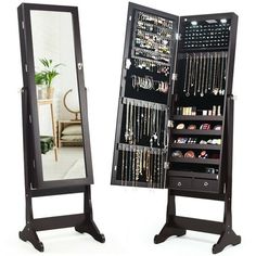 a black jewelry cabinet sitting next to a mirror