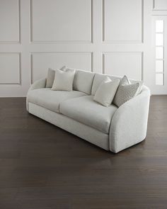 a white couch sitting on top of a hard wood floor