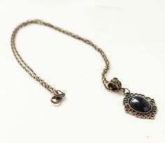 This romantic necklace is made from antique bronze chain and a black agate cabochon housed in an ornate filigree setting. This necklace is also available in antique silver finish. -the chain is 18 inches length -the pendant is approximately 1.25 inches long and 1 inch wide including the setting -lobster claw closure SHIPPING: Default shipping is by regular mail, which does not have tracking, shipping times are as follows: US: 1-3 weeks Canada: 1-2 weeks Europe: 2-4 weeks If you would like to add Black Pendant Necklace With Vintage Charm, Elegant Black Jewelry With Antique Finish, Elegant Metal Necklaces With Antique Finish, Elegant Metal Necklace With Antique Finish, Elegant Antique Finish Necklaces For Gifts, Elegant Oval Pendant Necklace With Antique Finish, Elegant Oval Pendant Jewelry With Antique Finish, Elegant Antique Finish Pendant Necklaces, Black Metal Necklace With Antique Finish