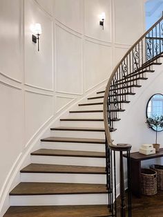 there is a staircase in the middle of this room with white walls and wood floors