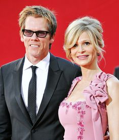 a man and woman standing next to each other on a red carpet at an event