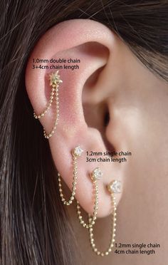 an ear piercing is shown with pearls and chains attached to the end of each ear