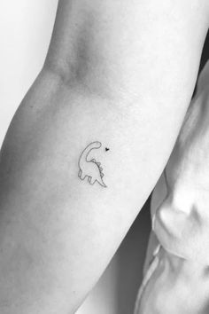 a small tattoo on the arm of a woman with an animal in it's left arm