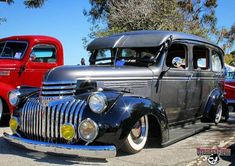 an antique car is parked in a parking lot with other classic cars behind it on display