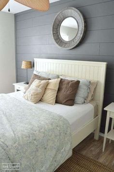 a white bed sitting in a bedroom next to a mirror on the side of a wall