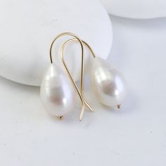 These earrings start with a matched pair of stunning genuine freshwater pearls. They each dangle on minimalist, custom 14K settings that I make by hand. My favorite thing about these earrings is how the large pearls look even more creamy smooth and luminous next to the bright, reflective gold. It's a lovely marriage and a perfect balance - minimal and super luxurious and feminine - they embody quiet luxury. The pearls are 15-16mm genuine, natural freshwater pearls. Made from solid 14K yellow gol Minimalist Yellow Gold Drop Pearl Earrings, Minimalist Teardrop Pearl White Earrings, Teardrop 14k Gold-filled Pearl Earrings For Anniversary, Pear-shaped Pearl Pendant Earrings In Minimalist Style, Teardrop 14k Gold Filled Pearl Earrings For Anniversary, 14k Gold Filled Teardrop Pearl Earrings For Anniversary, Elegant 14k Gold Filled Teardrop Earrings, Classic White Pearl Earrings In 14k Gold, Minimalist Yellow Gold Teardrop Pearl Earrings