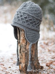 a knitted hat sitting on top of a tree stump