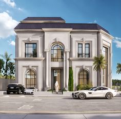 two cars are parked in front of a large white building with arched windows and palm trees