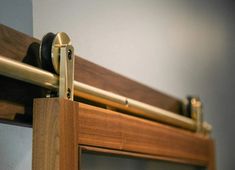 a close up view of a wooden door handle on a glass door with metal bars