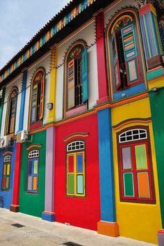 a row of multicolored buildings with motorcycles parked in front